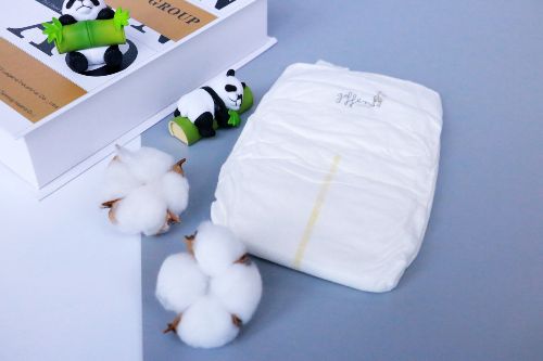 Geffen On the Go Bamboo Disposable Diapers placed next to a bamboo stick and cotton