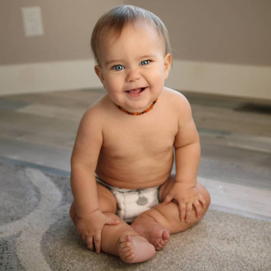 Toddler wearing a Geffen Baby snapless fitted being held closed by a snappi closure. 