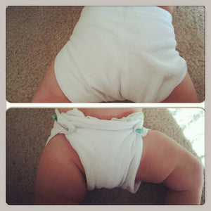 Baby wearing a geffen baby jersey hemp flat cloth diaper secured closed with cloth diaper pins